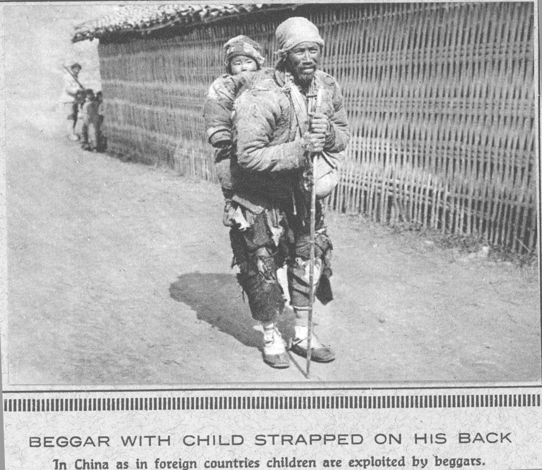 Beggar with child strapped on his back